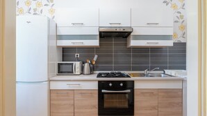 Eine kleine Küche mit Mikrowelle, Toaster, Gasherd und Backofen.