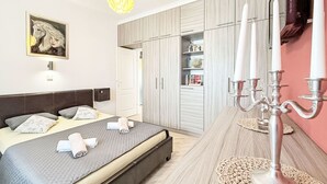 A modern bedroom with a bed, bedside tables, a wardrobe, and a candelabra.