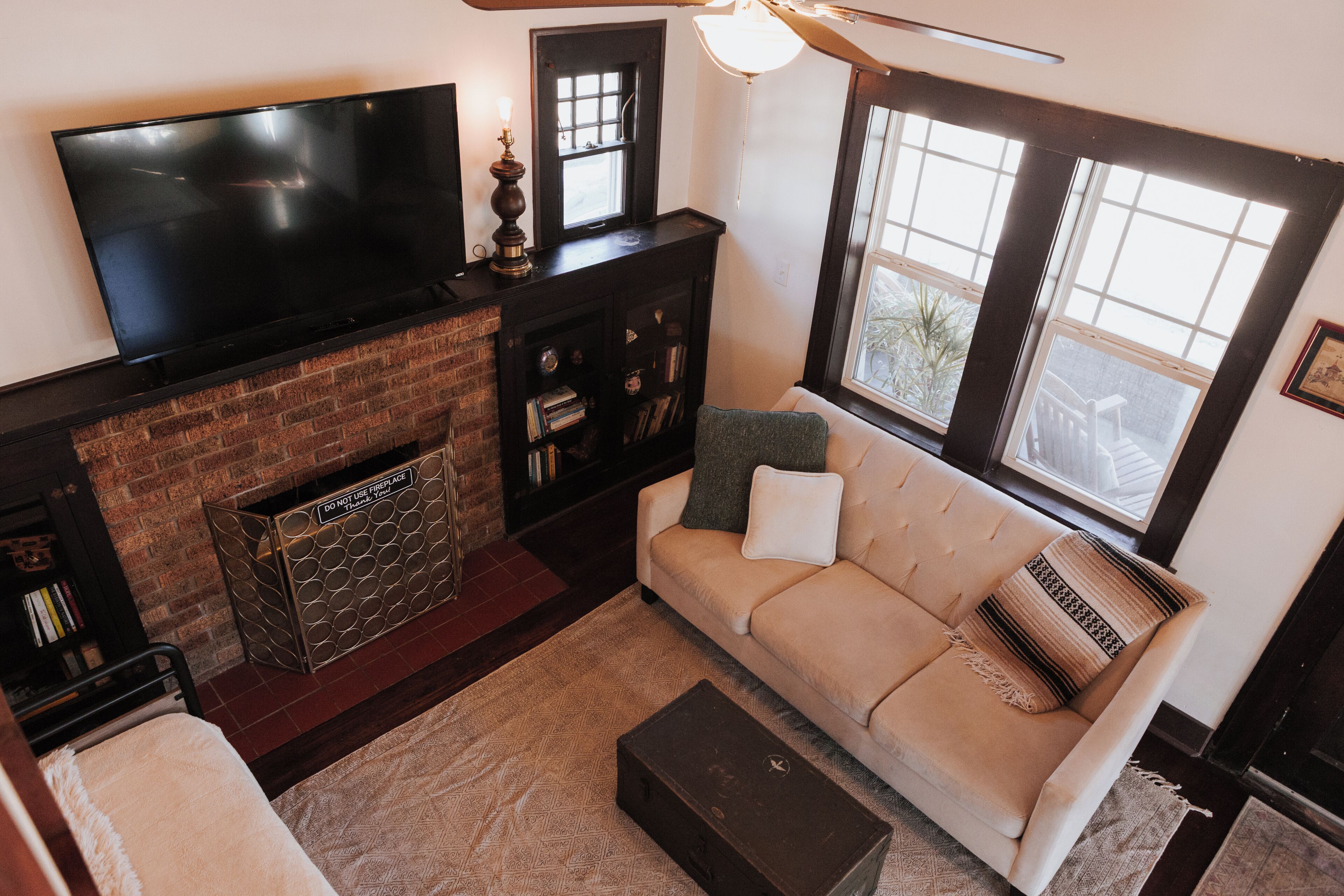A living room with a flat-screen TV, a fireplace, a sofa, and a window with a view.