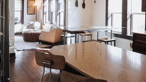 A modern kitchen with a large island, bar stools, and a dining area with a sofa and chairs. - Tranquil Pet-Friendly Bungalow in Midtown Springfield with High-Speed Wi-Fi (Springfield)