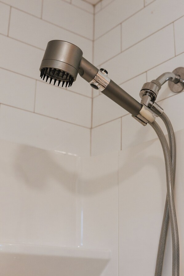 A showerhead attached to a wall with a flexible hose. - Tranquil Pet-Friendly Bungalow in Midtown Springfield with High-Speed Wi-Fi (Springfield)