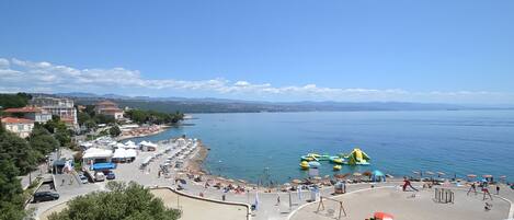 Relax on the promenade overlooking the calm sea, with beach umbrellas and sun loungers at your disposal.