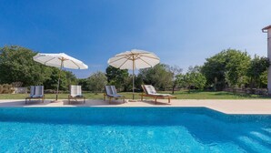 A swimming pool with lounge chairs and umbrellas. - Vacation home Lancin by Interhome (Pula/Marčana)