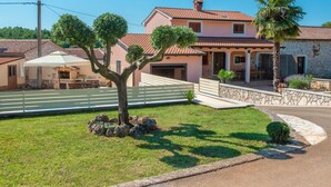 A two-story house with a stone facade, a tiled roof, and a well-maintained lawn. - Vacation home Medica by Interhome (Pazin)