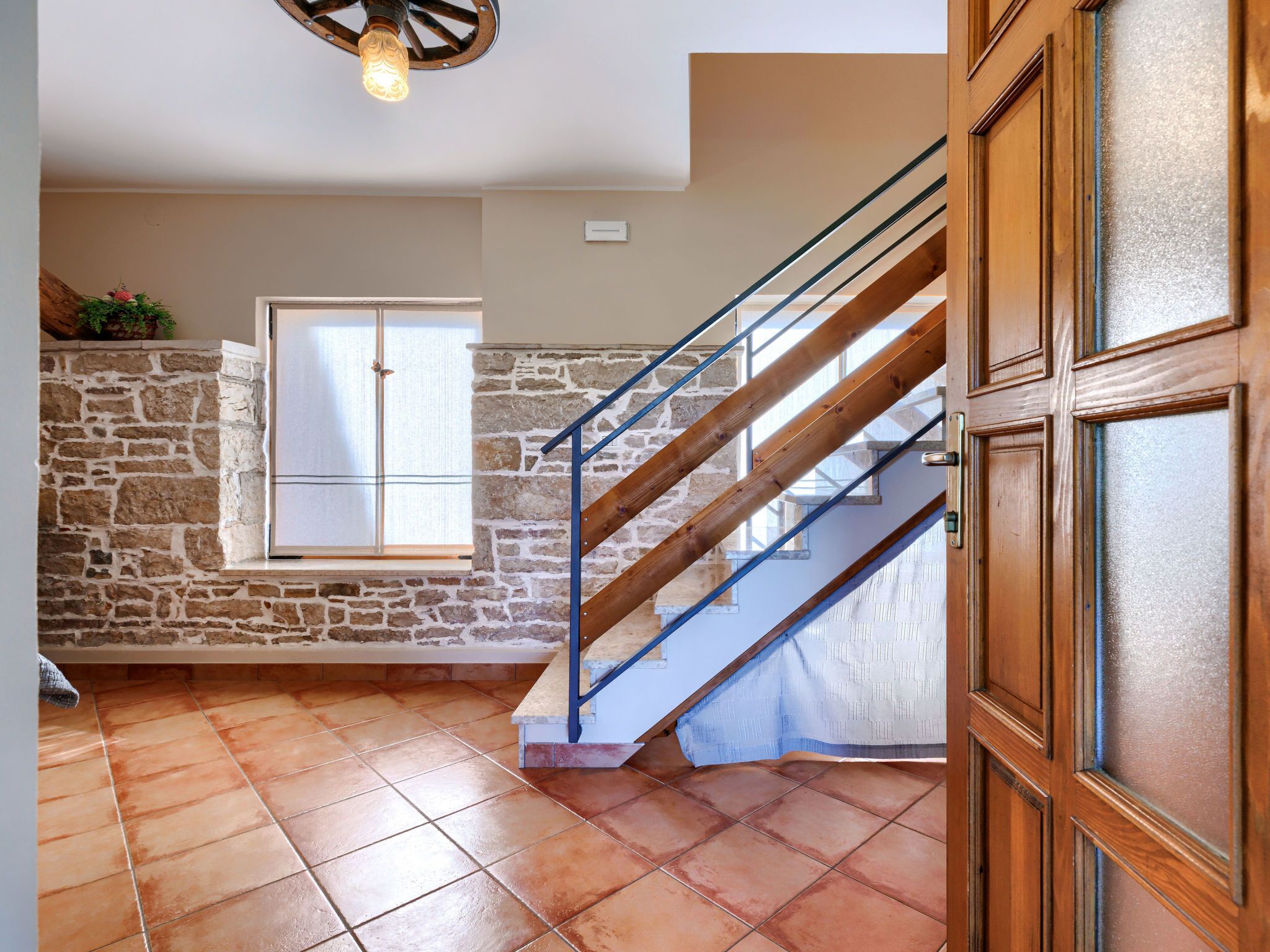 Una escalera con barandillas de madera y un muro de piedra.