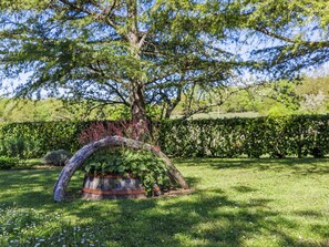 Escape to a serene garden oasis surrounded by lush greenery and a beautifully trimmed hedge.