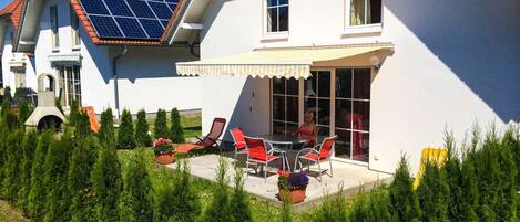 A house with a patio, solar panels, and a garden.