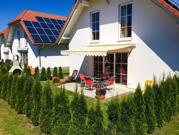 A house with a patio, solar panels, and a garden.