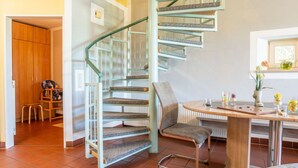 A spiral staircase with a wooden finish and metal railings, leading to an upper floor. - Ferienhäuser Schlossberg by Interhome (Zandt)