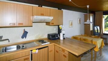 Køleskab, højstol, køkkentøj/tallerkener/redskaber, spisebord