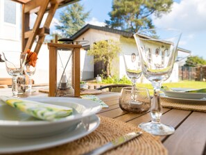 A wooden table set for a meal with clear glassware, a candle, and a rustic lantern. - Vacation home Bruni by Interhome (Manderscheid)