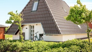 A modern house with a sloped roof, a small attached garage, and a bicycle parked outside.