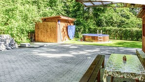 A covered outdoor area with a wooden bench, picnic table, and barbecue grill. - Vacation home Jirka by Interhome (Dehtáře)