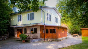 A two-story house with a porch, a stone wall, and a paved driveway. - Vacation home Jirka by Interhome (Dehtáře)