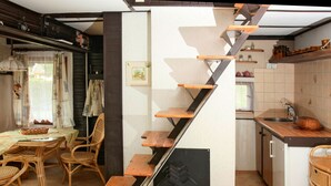 A kitchen with a wooden staircase, wicker furniture, and tiled flooring. - Vacation home Jiri by Interhome (Dehtáře)