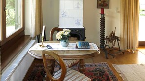 Un comedor con chimenea, una mesa con un florero y una silla.