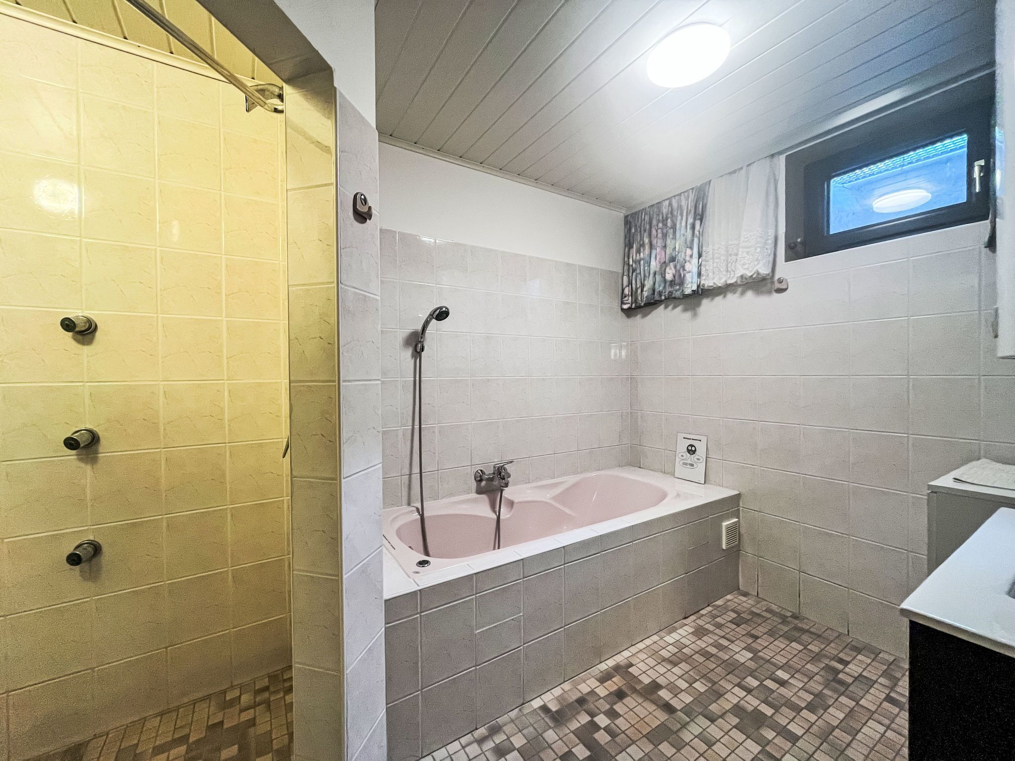 A bathroom with a shower, a bathtub, and a sink.