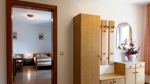 Ein Holzschrank mit Spiegel und ein kleiner Tisch mit Topfpflanze.