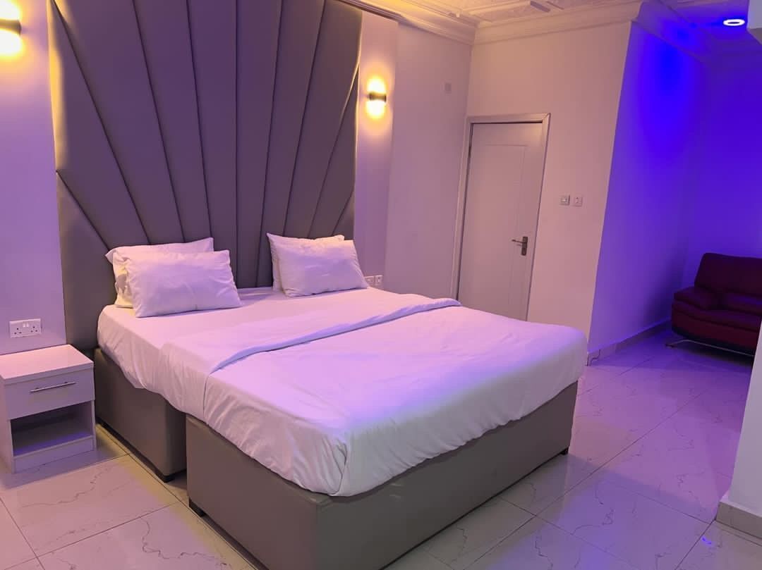 Ein modernes Schlafzimmer mit einem großen Bett, einem Nachttisch und einem Kleiderschrank.