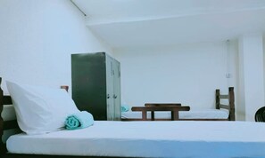 A single bed with a wooden headboard, a small table, and a wardrobe. - Hostel BARRA FUNDA LTDA  (São Paulo)