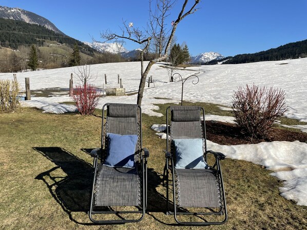 Two outdoor chairs with cushions, a tree, and a snow-covered landscape with mountains in the background. - Gassreith by Interhome (Sankt Johann in Tirol)