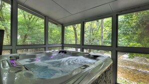 A hot tub with a view of a forest through large windows. - Riverside relaxation and all the comforts of home! - Aska River House (Blue Ridge)