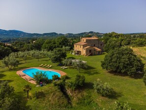 A villa with a swimming pool surrounded by lush greenery and hills in the background. - Apartment Malva by Interhome (Pitigliano)
