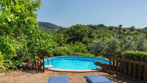 Une piscine avec deux chaises longues en bois et une clôture en bois.