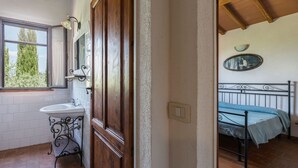 Une salle de bain avec un lavabo, un miroir et une porte en bois.
