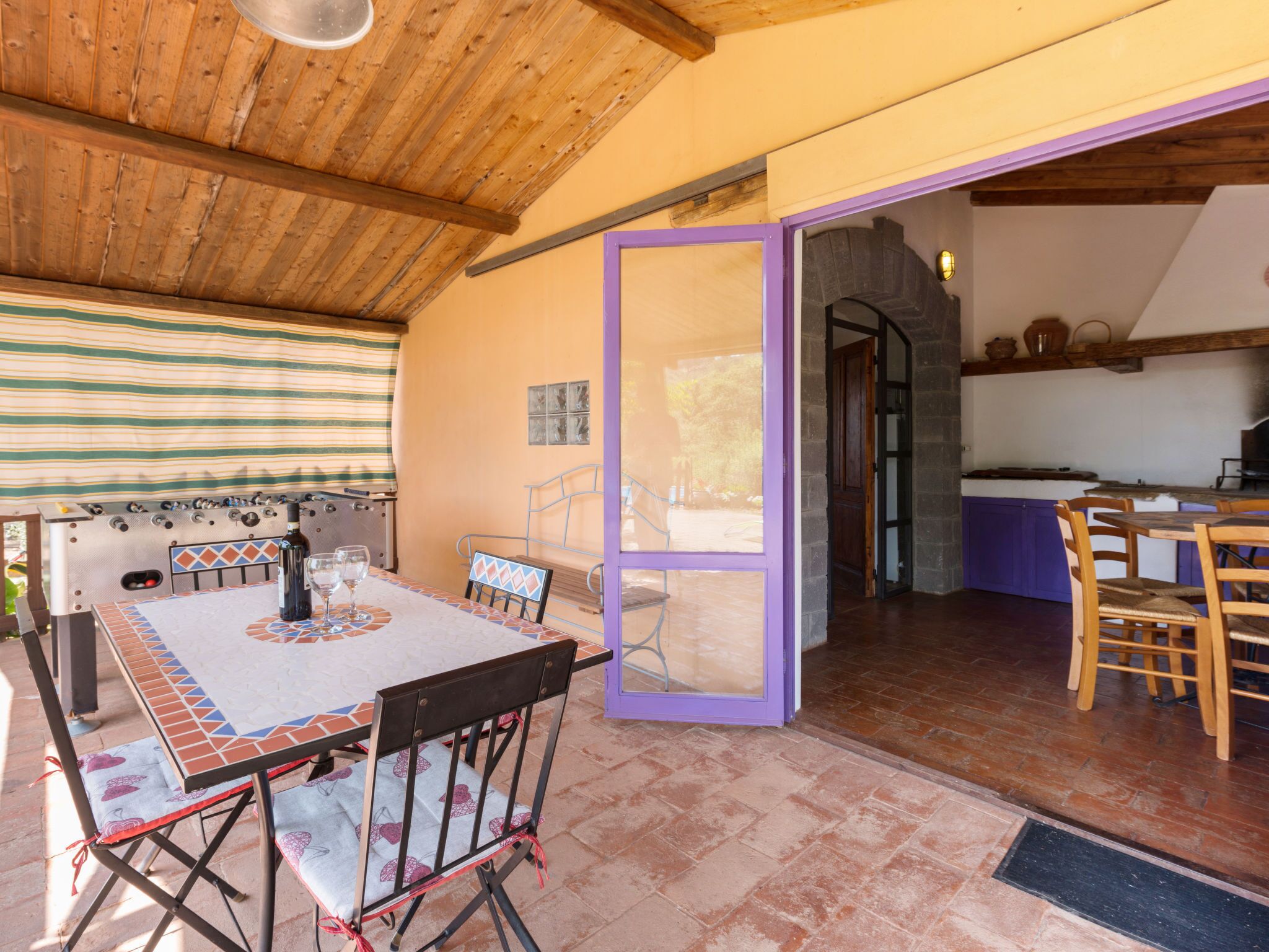 Un espacio de estar abierto con una mesa de comedor, sillas y una cocina visible a través de un arco.