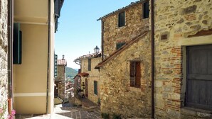 Eine enge Gasse mit traditionellen Gebäuden, einem kleinen Fenster und einer Tür.