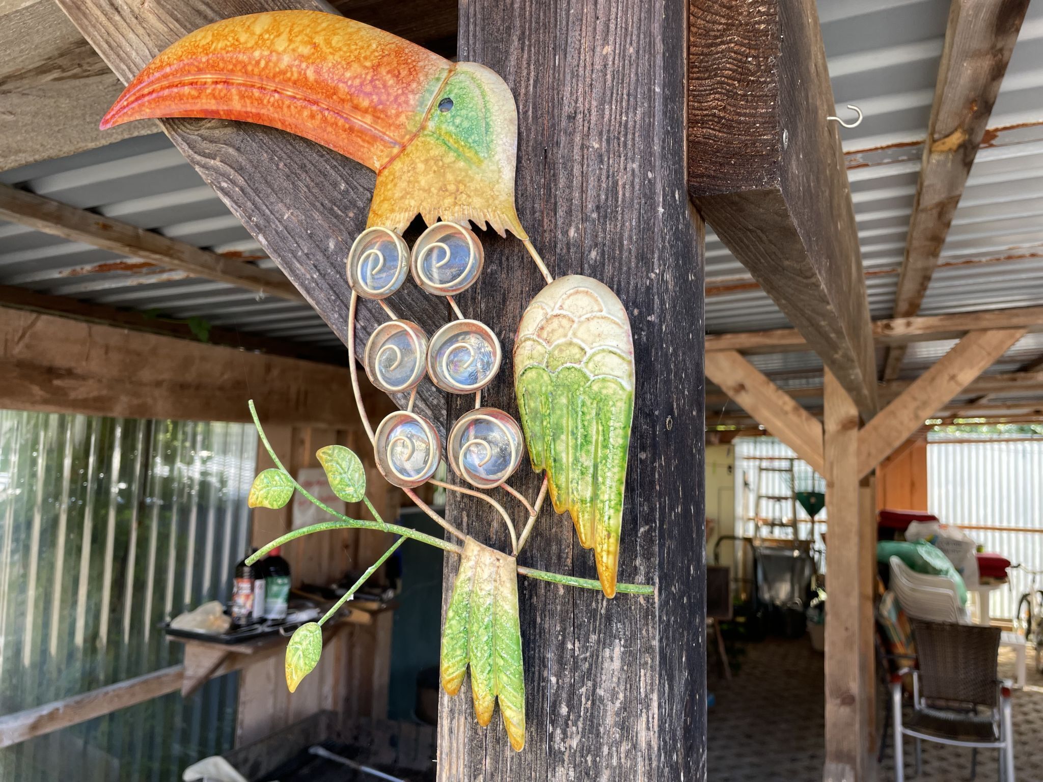 Una estructura de madera con una escultura decorativa de un pájaro y varios objetos circulares adheridos.