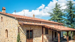 A stone building with a tiled roof, a covered patio, and a grassy lawn. - Villa al Sole by Interhome (Montalcino)