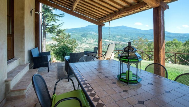 An outdoor patio with a wooden pergola, a table, chairs, and a lantern. - Villa al Sole by Interhome (Montalcino)