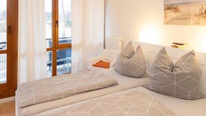 A bedroom with a bed, pillows, a nightstand, and a painting on the wall. - Strandvilla (LUB117) by Interhome (Ostseebad Lubmin)
