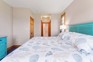 A bedroom with a bed, a nightstand, a dresser, and a door leading to a bathroom. - 3 br, dogs, canal front, sunrises/sunsets! (Avon)