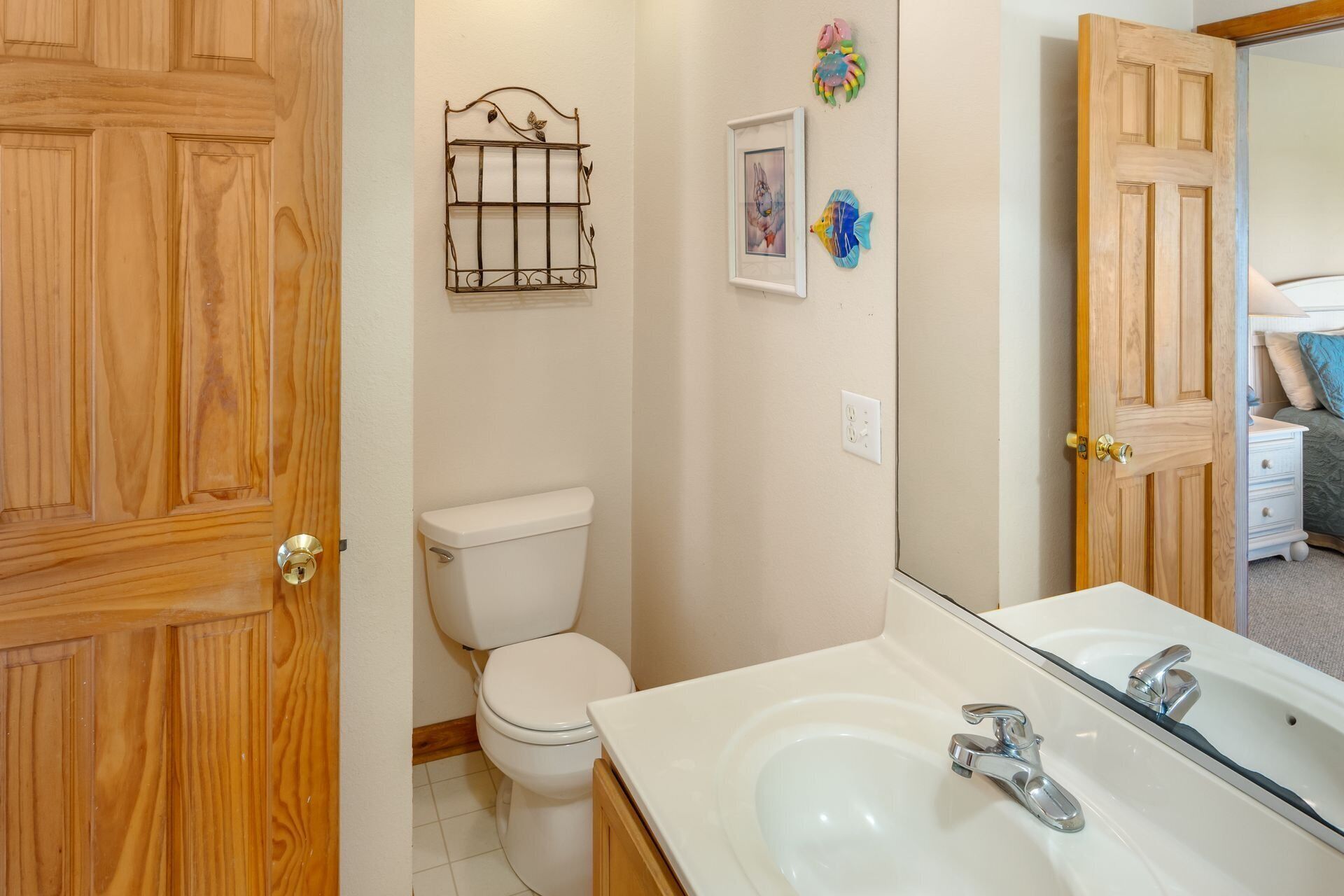 A bathroom with a toilet, a sink, and a mirror.