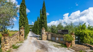 A stone pathway leading to a gate with a sign reading "Podere Tre Termini." - Podere Tre Termini by Interhome (Cecina)