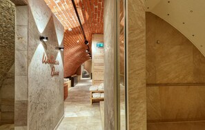A hallway with a brick ceiling, a sign reading "Wellness Oasis," and a wooden bench. - Stunning apartment in Quedlinburg (Quedlinburg)