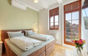 A bedroom with a bed, bedside tables, a radiator, and a window with blinds. - Stunning apartment in Quedlinburg (Quedlinburg)
