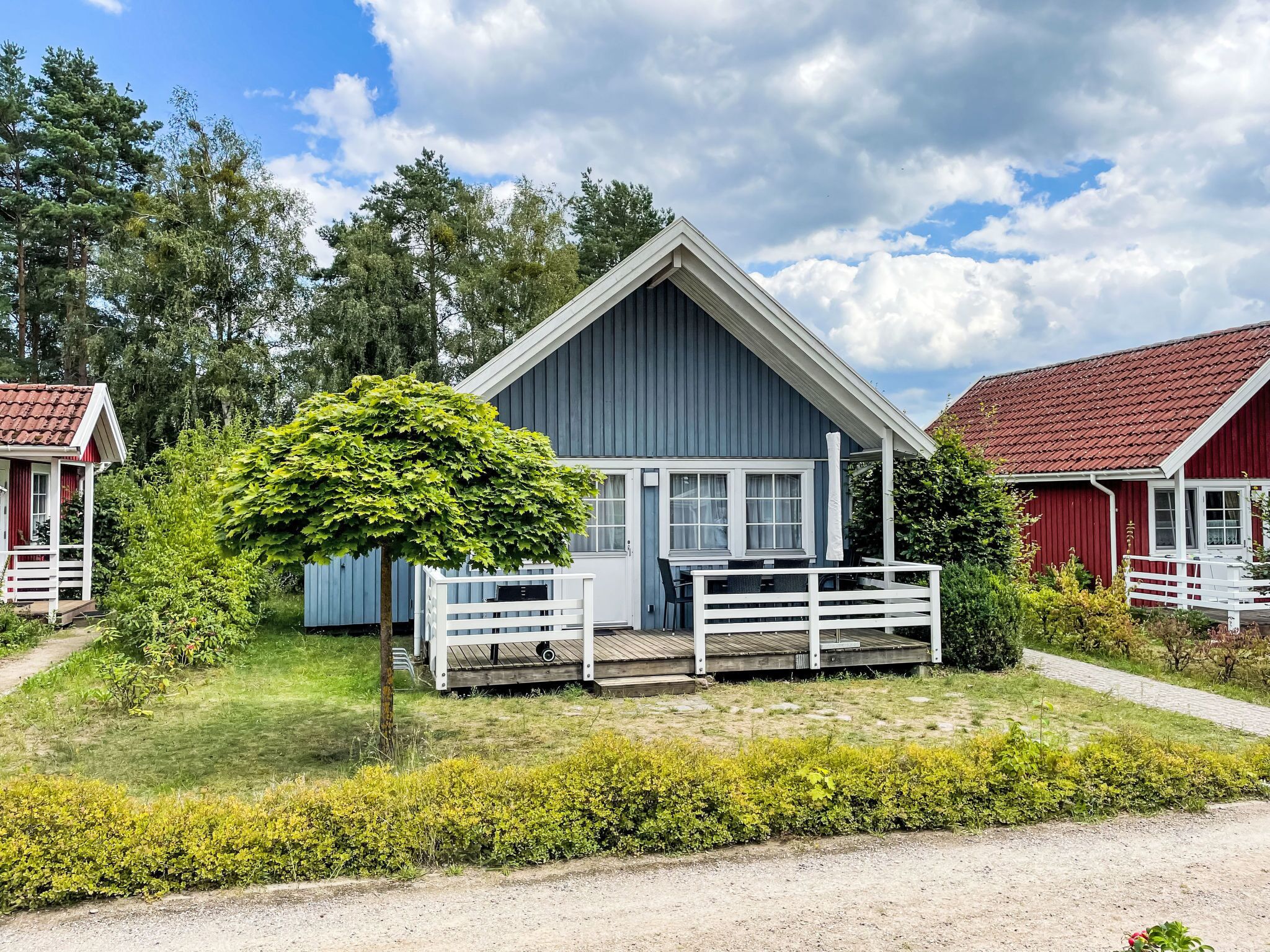 A two-story barn-style building with a white porch and a red roof.