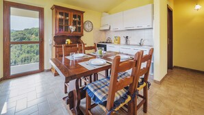 A dining area with a wooden table, chairs, and a clock on the wall.