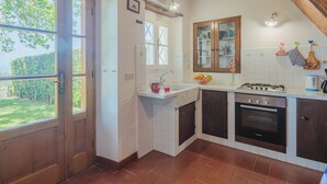 Une cuisine avec un plafond en bois, une fenêtre, un évier, des placards et un four Bosch.