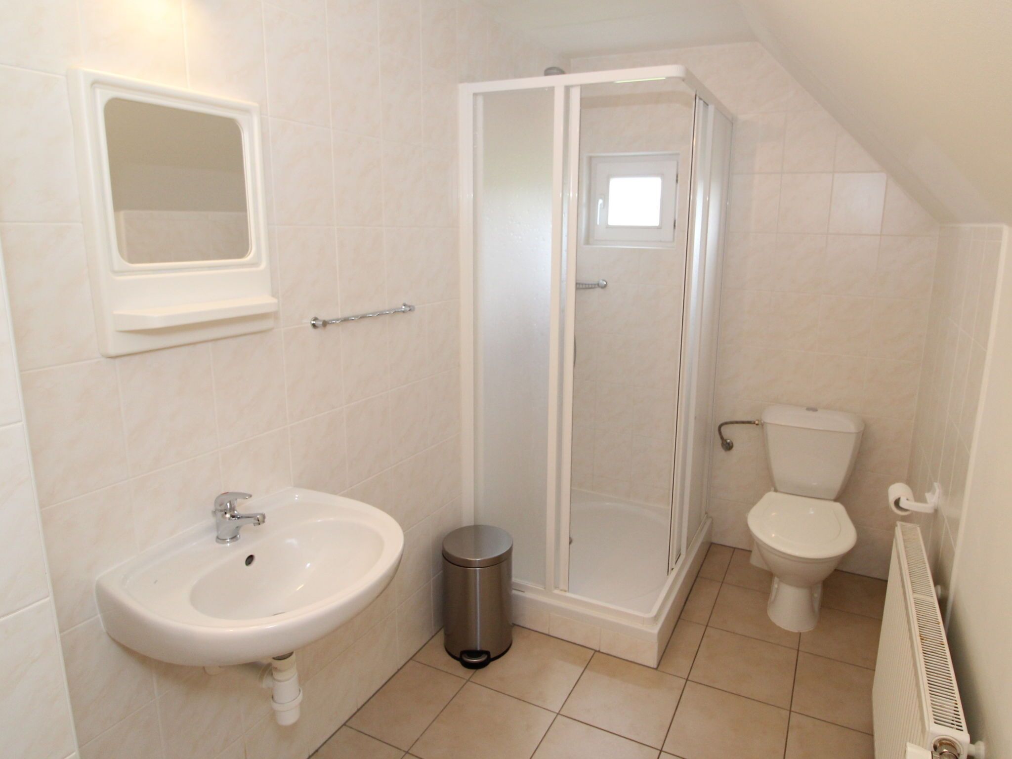 Un bagno con lavandino, WC e doccia.