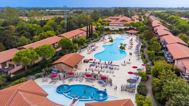 Un resort con varias piscinas, tumbonas y sombrillas.