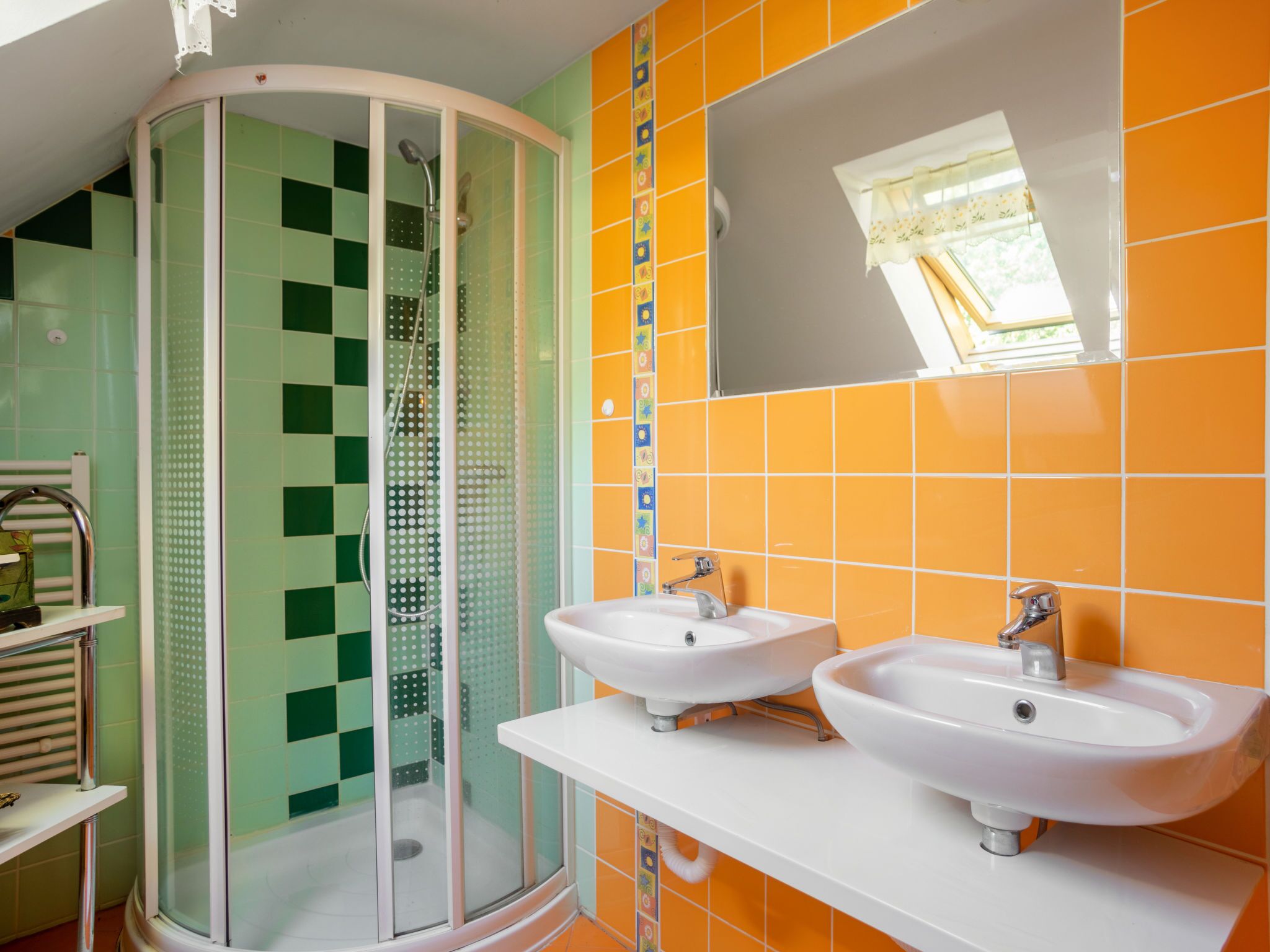 A bathroom with a glass shower enclosure, two sinks, and a large mirror.