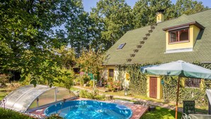 Un pati amb piscina, un hivernacle i una casa amb teulada inclinada i vital.