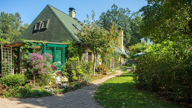 Una casa amb un teulat verd i un camí al jardí que hi condueix.