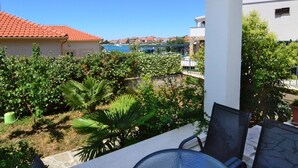 A balcony with a view of a coastal town, greenery, and a clear blue sky. - Katarina 4 by Interhome (Šibenik)