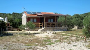 A two-story house with a red-tiled roof, a stone chimney, and a small porch with a wooden railing. - Kalebica by Interhome (Pašman/Pašman)
